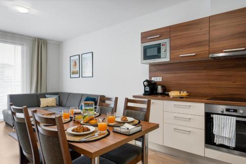 a kitchen with a table with food and orange juice at Apart Hotel VIRGO in Bratislava