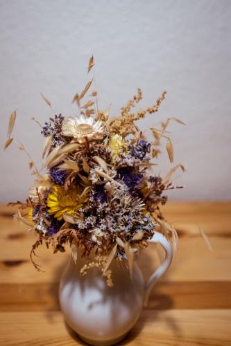 a vase with a bouquet of flowers in it at Penzion Statek u Rajtrů in Bedřichov