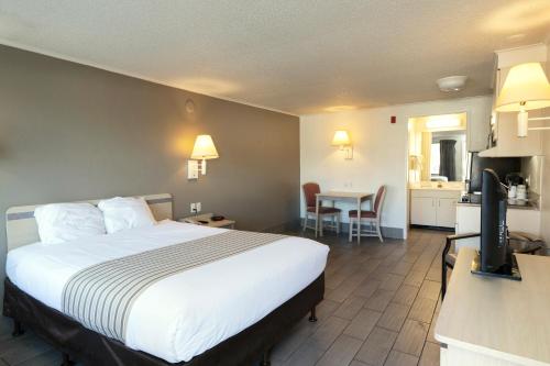 a hotel room with a bed and a kitchen at Suburban Studios Mentor - Cleveland Northeast in Mentor
