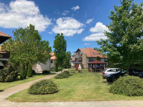 a yard with a car parked in front of a house at Beatrix apartman in Balatonőszöd