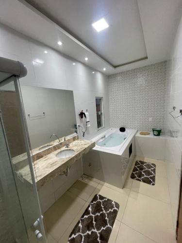 a bathroom with a tub and a sink and a mirror at POUSADA CECILIA in Canindé de São Francisco