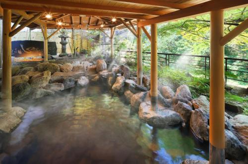 福島市にある奥飯坂 穴原温泉 匠のこころ 吉川屋の水の中に岩がある庭園の温泉