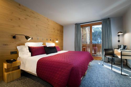 Hotel Xalet Montana في سولديو: غرفة فندق بسرير كبير ومكتب ومكتب