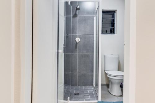 a glass shower in a bathroom with a toilet at The Lillies Luxury Apartment in Midrand