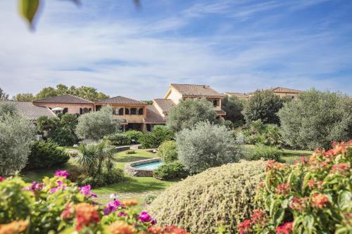 a house with a garden with flowers in the foreground at Hotel Baia Di Nora in Pula