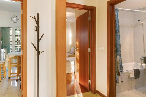 un baño con una puerta de cristal que conduce a un baño con bañera en Oliveira Atlantic View, en Funchal