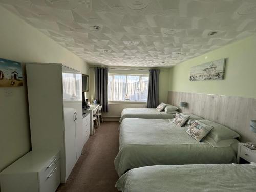 een slaapkamer met 2 bedden en een plafond bij Leeward House B&B in Gosport