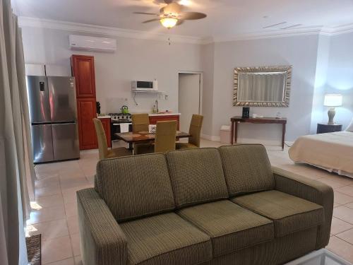 ein Wohnzimmer mit einem Sofa und einem Bett sowie eine Küche in der Unterkunft Sandpiper Beach Apartments in Palm-Eagle Beach