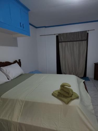 - une serviette verte assise au-dessus du lit dans l'établissement Bella Louise Bar Resto, à Busuanga