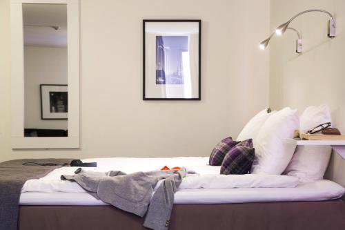a bedroom with a bed with white sheets and pillows at Best Western Kom Hotel Stockholm in Stockholm