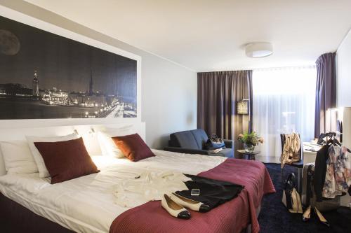 a hotel room with a bed with shoes on it at Best Western Kom Hotel Stockholm in Stockholm