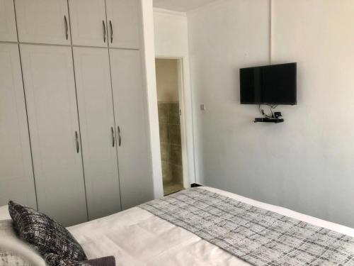 a bedroom with a bed and a flat screen tv at 1 bed apartment in Mount Pleasant Heights - 2014 in Kingsmead
