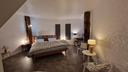 1 dormitorio con 1 cama, mesa y sillas en Domaine Le Puits du Moulin, en Comberjon