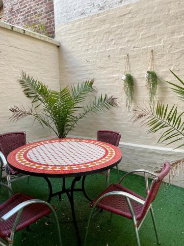 une table et des chaises de patio avec une table et une plante dans l'établissement La Batelière, appartement mer avec patio privé, à Mers-les-Bains