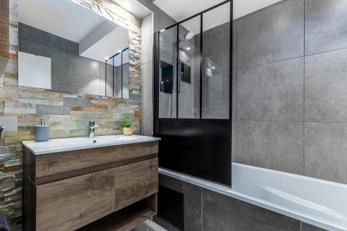 La salle de bains est pourvue d'un lavabo et d'une douche. dans l'établissement Sunset Appart-Hotel 3 chambres, 2 Salles de Bain, proche Paris, Massy & Orly, à Longjumeau