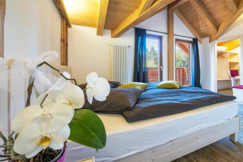 een slaapkamer met een groot bed met witte bloemen erop bij Hotel Rifugio Sores in Coredo