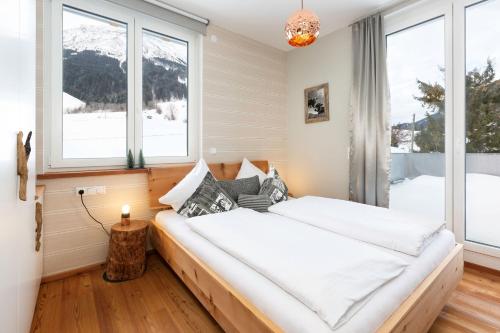 una camera da letto con un grande letto e una finestra di Chalet am Breitenberg Appartement CB 04 a Pfronten