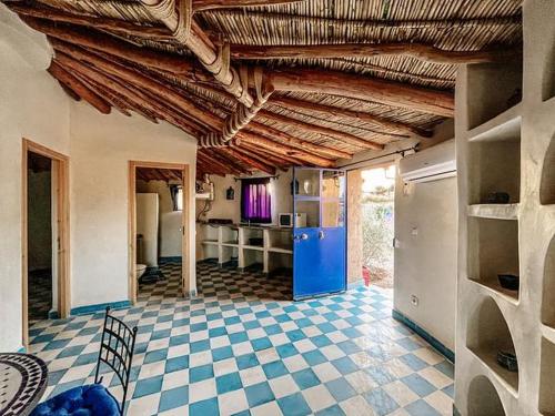 a kitchen with a blue refrigerator and a tile floor at Les Jardins d Amizmiz in Amizmiz