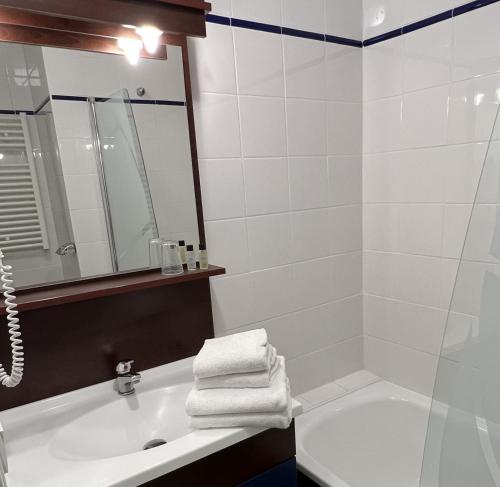 a bathroom with a tub and a sink and a mirror at Vacancéole - Appart'Vacances Pyrénées 2000 in Bolquere Pyrenees 2000