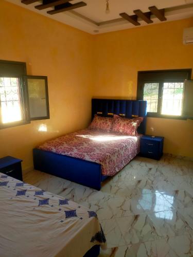 um quarto com uma cama e duas janelas em Appartement Islam em Ouzoud