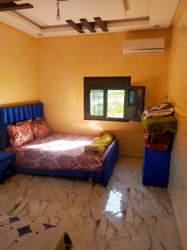 um quarto com uma cama num quarto com uma janela em Appartement Islam em Ouzoud