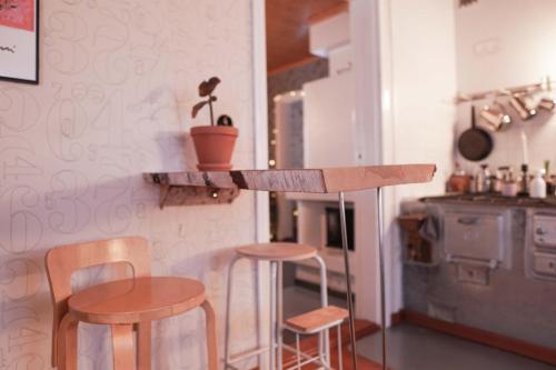a kitchen with two tables and two stools and a counter at Arctic Garden Design Villa in Rovaniemi