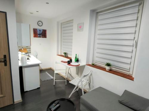 um quarto com uma mesa e uma cozinha com uma janela em Studio Piekary 1-go Maja em Piekary Śląskie