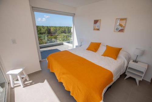 a bedroom with a large bed and a large window at 3 ambientes en Complejo de Lujo in Pinamar