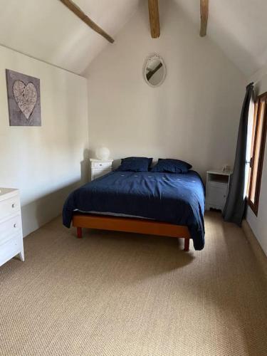 - une chambre avec un lit doté d'une couverture bleue dans l'établissement Maison avec exterieur, à Bû