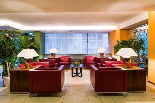 a waiting room with red chairs and plants at Quality Hotel Vienna in Vienna