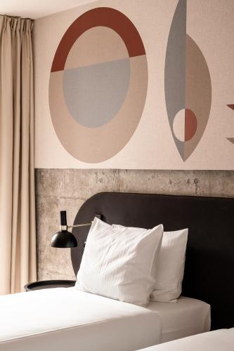 a bedroom with a bed with a large painting on the wall at Forest Hotel in Kraków