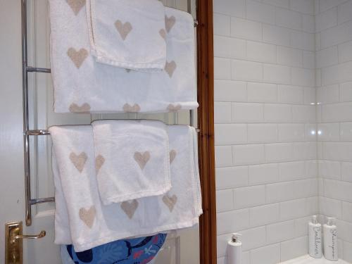 a bathroom with white towels with hearts on them at Belv House in Weymouth