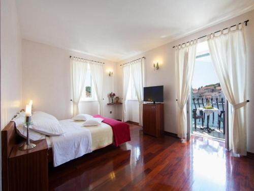 a bedroom with a large bed and a balcony at Villa Slika in Milna