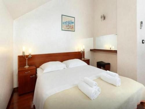 a bedroom with a large white bed with two white towels at Villa Slika in Milna