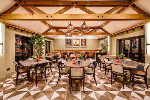 a restaurant with tables and chairs on a checkered floor at voco Lythe Hill Hotel & Spa, an IHG Hotel in Haslemere