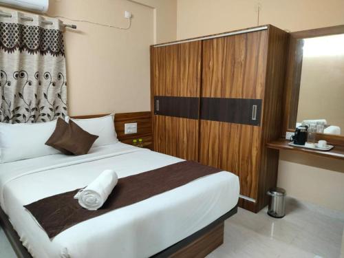 1 dormitorio con 1 cama grande y cabecero de madera en Golden Chariot 1BHK Flat-Manyata Tech Park, en Bangalore