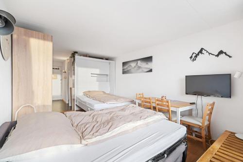 um quarto de hospital com duas camas e uma televisão em Chaleureux studio à Anzère, accessible à ski, proche de tout em Anzère