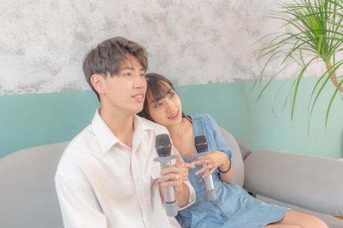 a young man and woman sitting on a couch playing a video game at HiHi Skylight in Hengchun