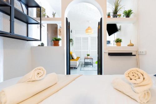 een slaapkamer met een wit bed en 2 handdoeken bij Congresos Centro in Torremolinos