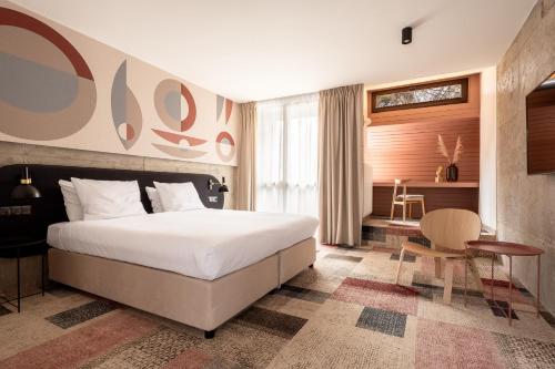 a bedroom with a bed and a table and a chair at Forest Hotel in Kraków