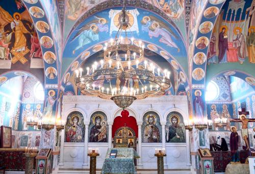 a church with colorful ceilings and a chandelier at Russian Pilgrim Residence in Sowayma