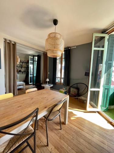uma sala de jantar com uma mesa de madeira e cadeiras em L'appartement Mersois - 50m de la mer & cosy em Mers-les-Bains