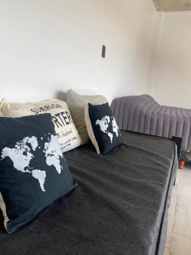 a bed with two black and white pillows on it at 126 Suite Centro II in Suipacha