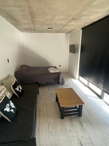a living room with a couch and a large screen at 126 Suite Centro II in Suipacha