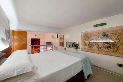 - une chambre avec un lit blanc et une peinture murale dans l'établissement Loft Margutta per Smart Worker, à Rome