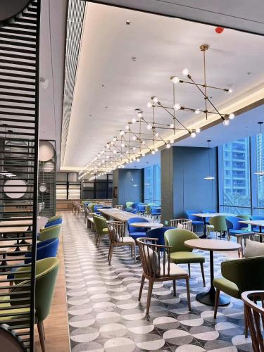 a dining room with tables and chairs and windows at EVEN Suzhou Grand Canal by IHG in Suzhou