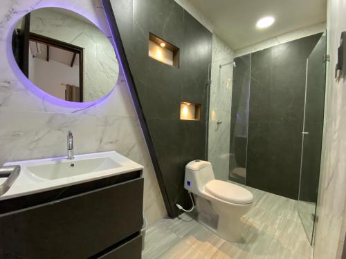 La salle de bains est pourvue d'un lavabo, de toilettes et d'un miroir. dans l'établissement Malibu beach, à Punta de Piedra
