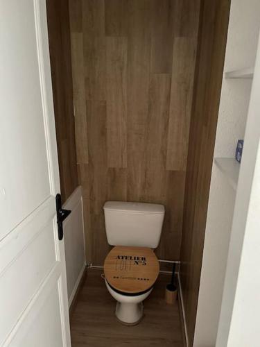 a small bathroom with a toilet with a wooden seat at Appartement lumineux avec superbe vue in Eaux-Bonnes