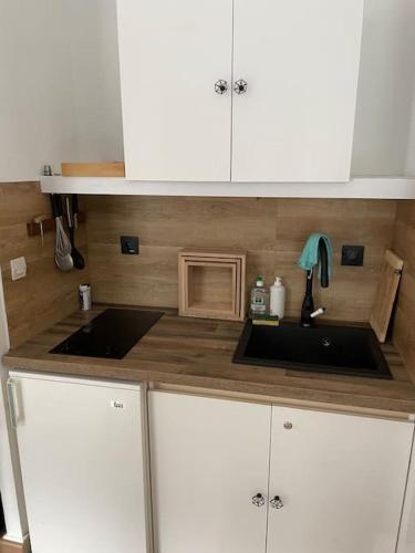 a kitchen with white cabinets and a sink at Appartement lumineux avec superbe vue in Eaux-Bonnes