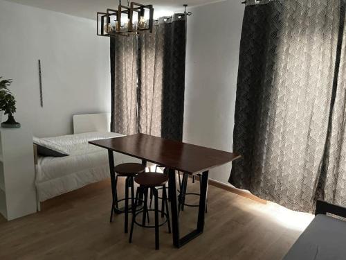 - une table et des tabourets dans une chambre avec un lit dans l'établissement Appartement lumineux avec superbe vue, à Eaux-Bonnes